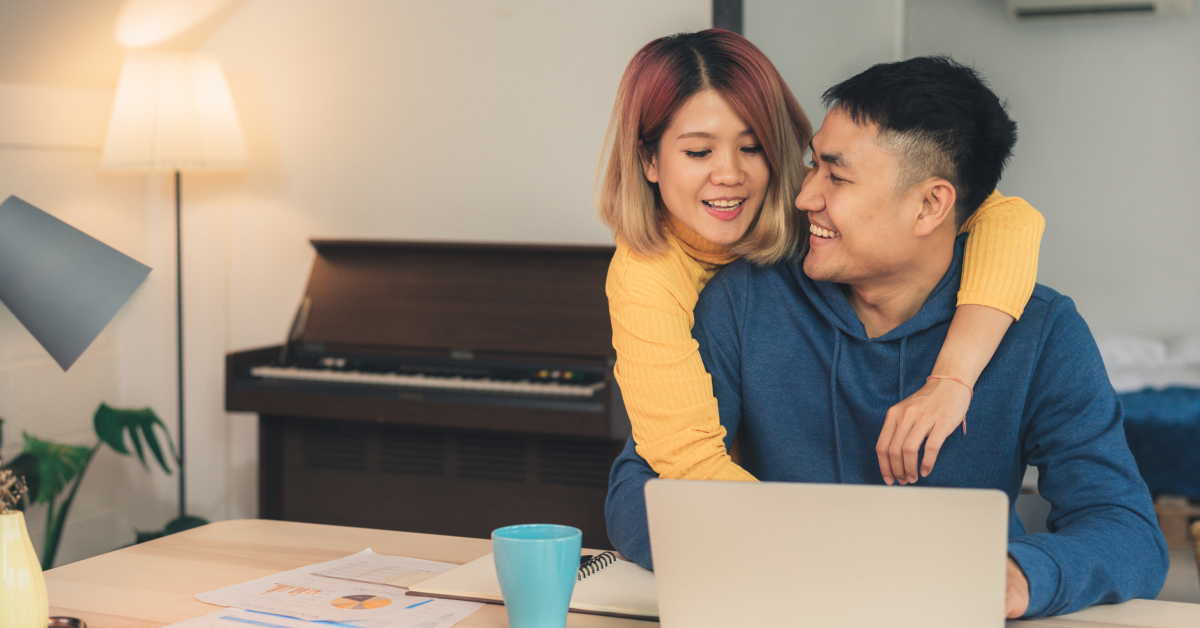 Header image: Couple in dining room managing finances together via laptop